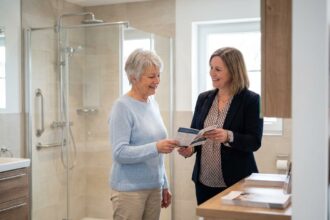 Femme senior souriante recevant des brochures dans une salle de bain moderne