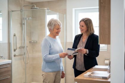 Femme senior souriante recevant des brochures dans une salle de bain moderne